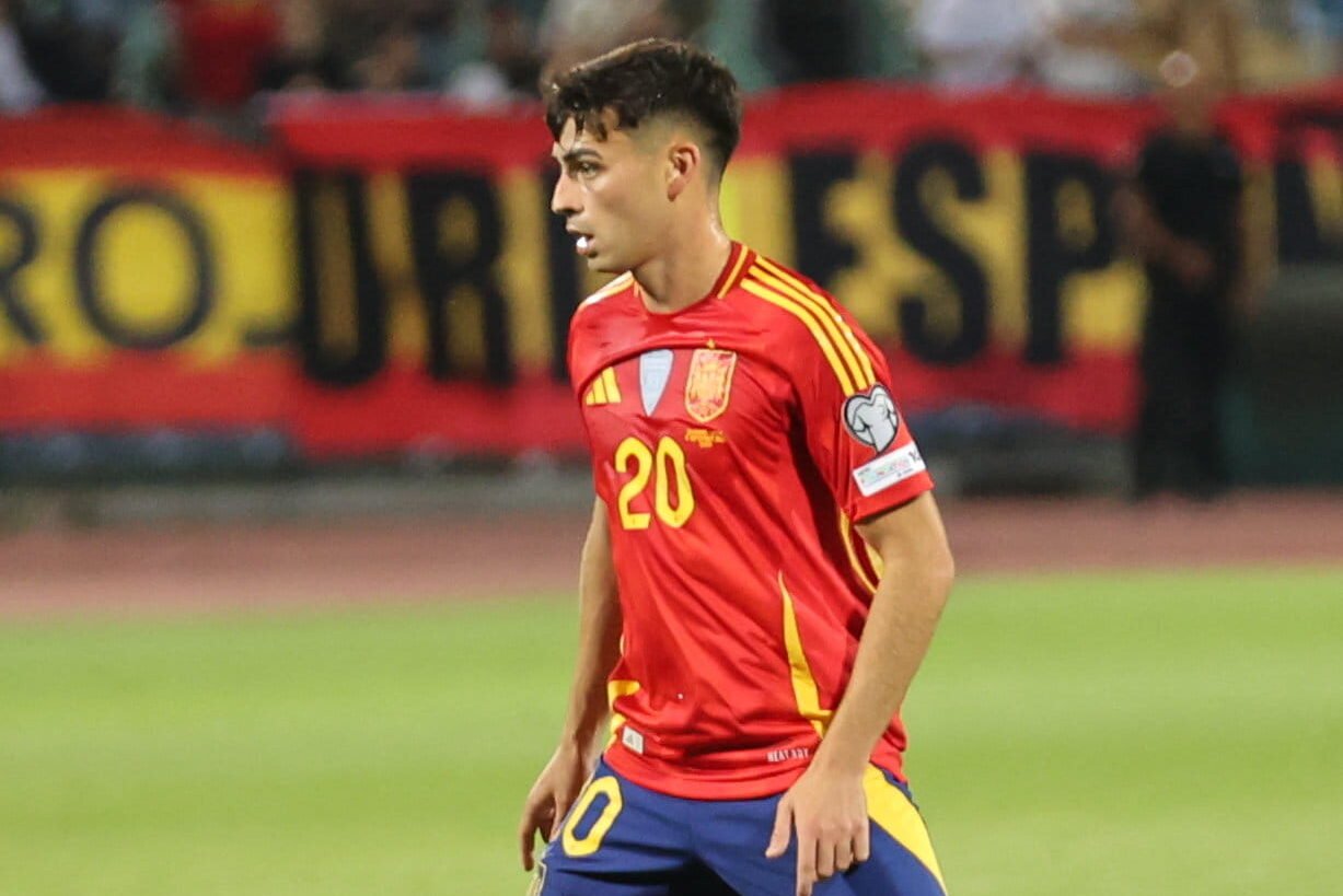 Pedri of Spain national team controlling the ball in midfield during a football match showing his passing vision and technical skill.