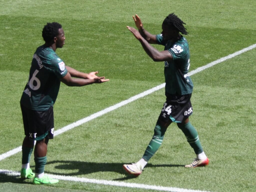 Nestory Irankunda dribbles past defenders for Australia.